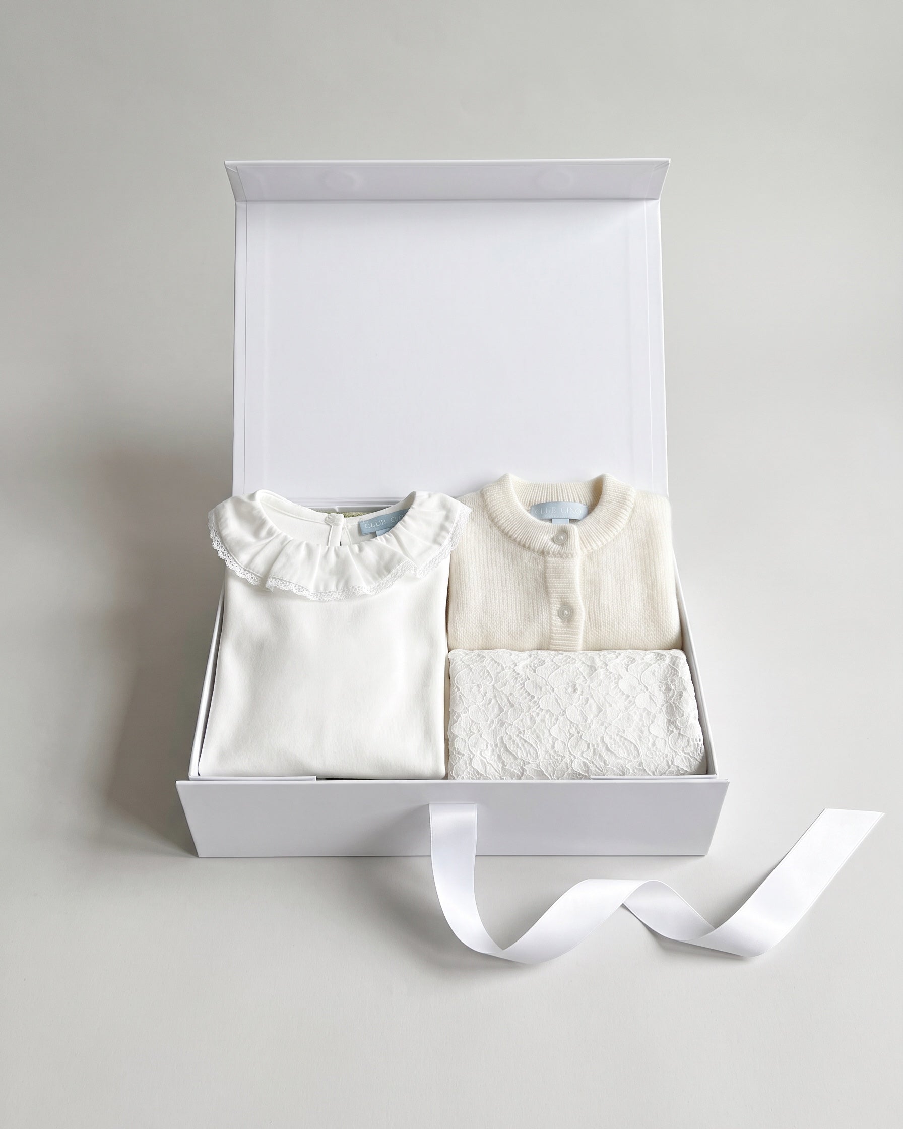 Gift set N°3 Lace & alpaca: white Club Cinq gift box with Hampton top white Pierrot lace collar, Cardigan alpaca and Bahia skirt white lace, neatly folded, with a white satin ribbon