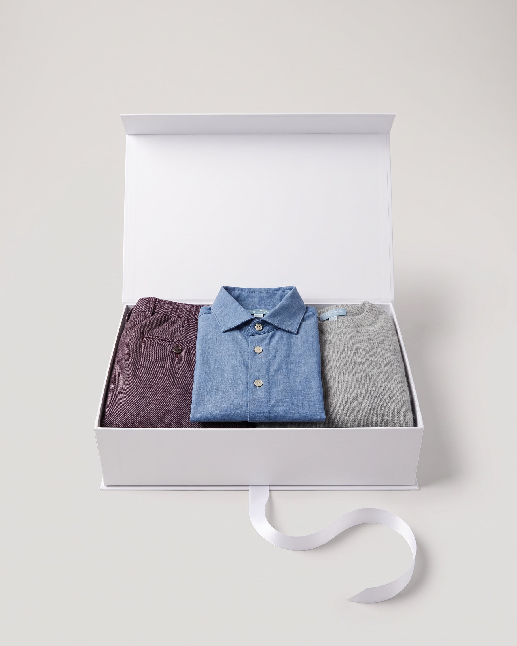 Gift set N°7 Burgundy & chambray: white Club Cinq gift box with James' trousers burgundy, Braga shirt chambray and Wool sweater heather grey, neatly folded, with a white satin ribbon